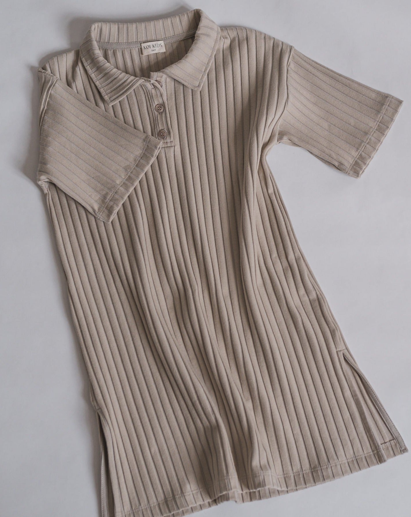 Beige midi length shirt dress in a ribbed jersey fabric. Relaxed fit with elbow length sleeves and a collar neckline with 3 buttons and split hem in both sides.