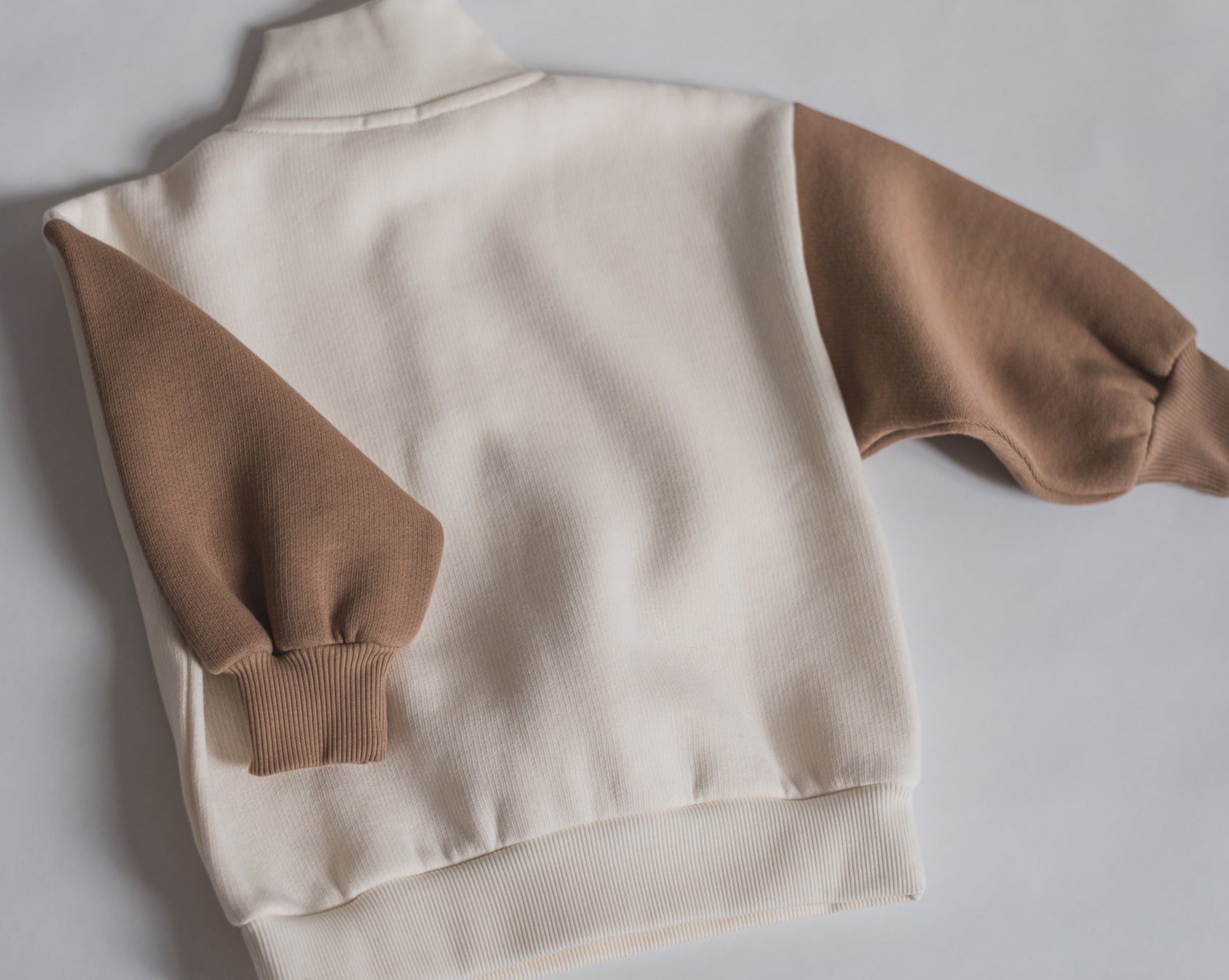 Offwhite sweatshirt with brown contrast sleeves, foldable cuffs with an oversized fit.