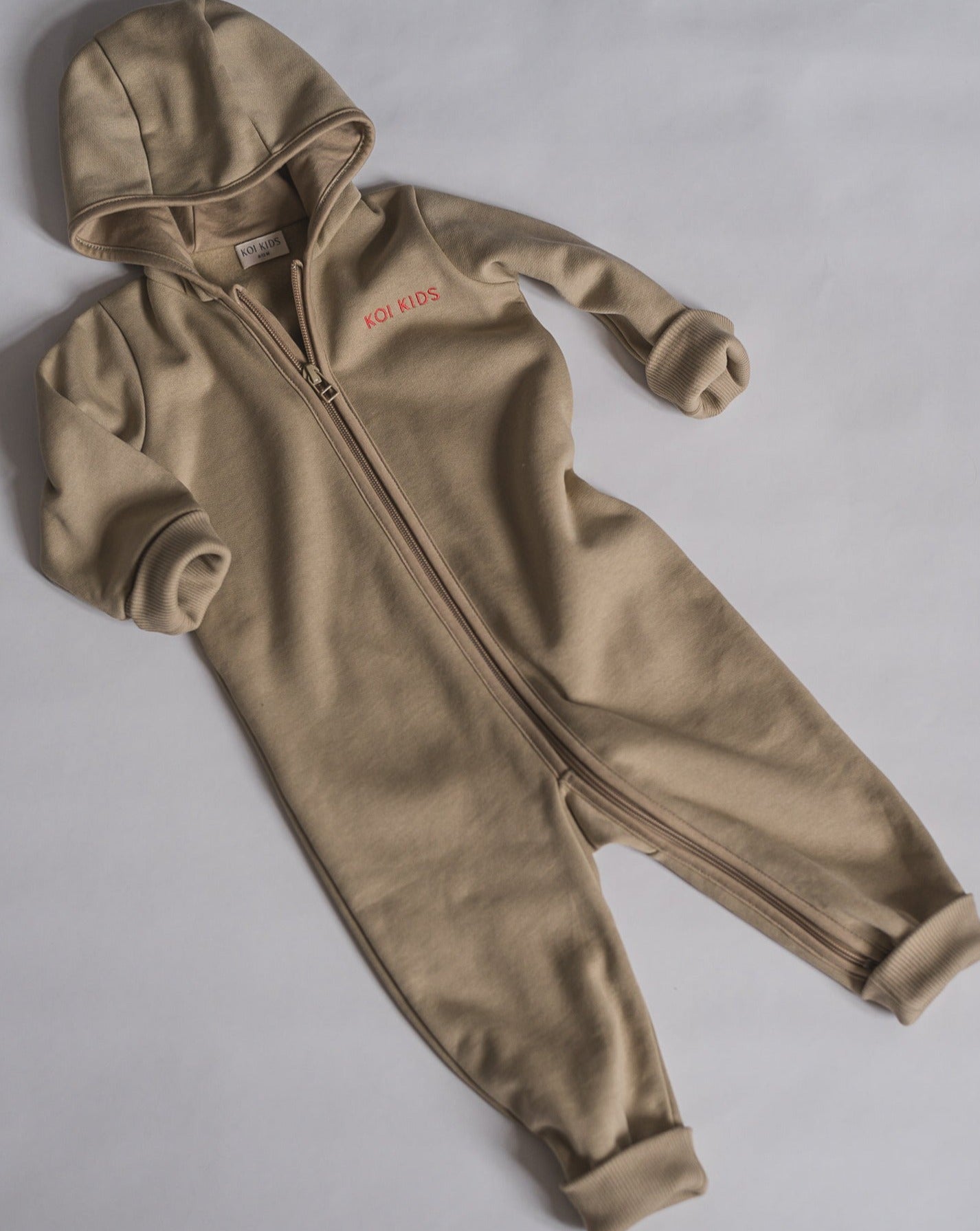 Beige overall with zipper and hoodie. Made of the softest brushed organic cotton jersey.
