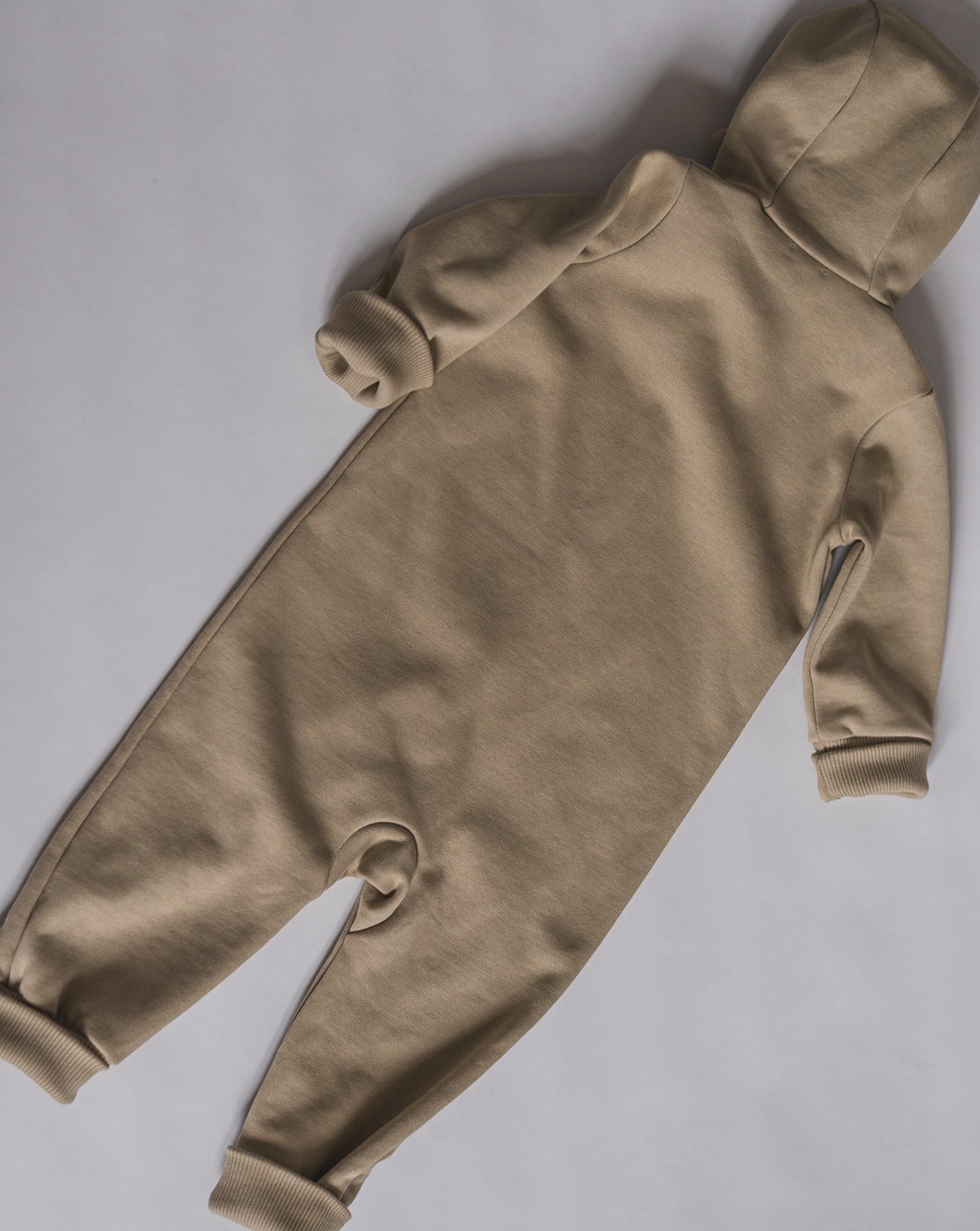 Beige overall with zipper and hoodie. Made of the softest brushed organic cotton jersey.