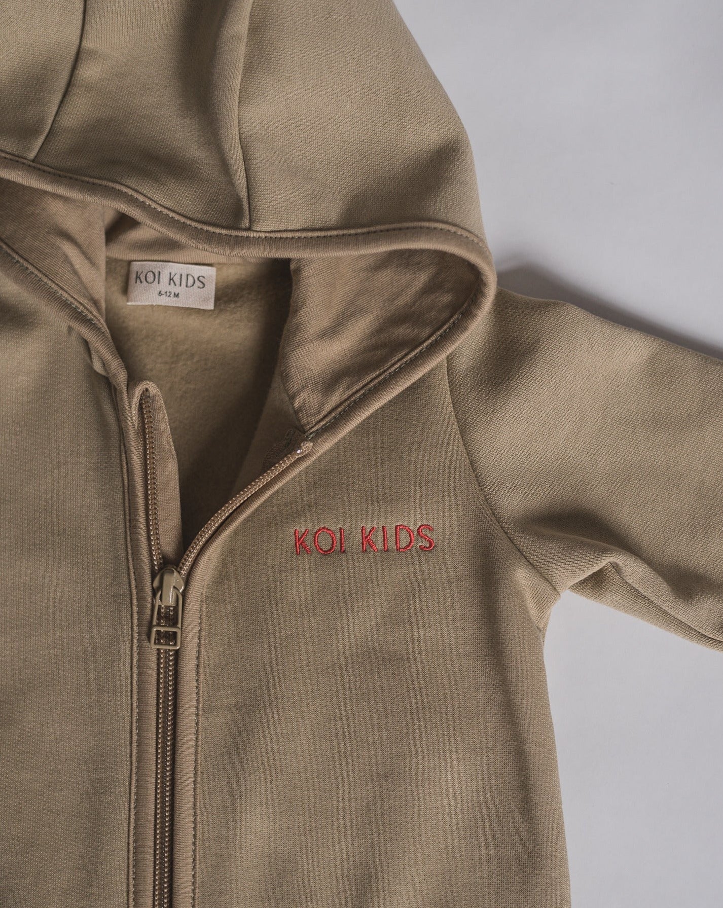 Beige overall with zipper and hoodie. Made of the softest brushed organic cotton jersey.