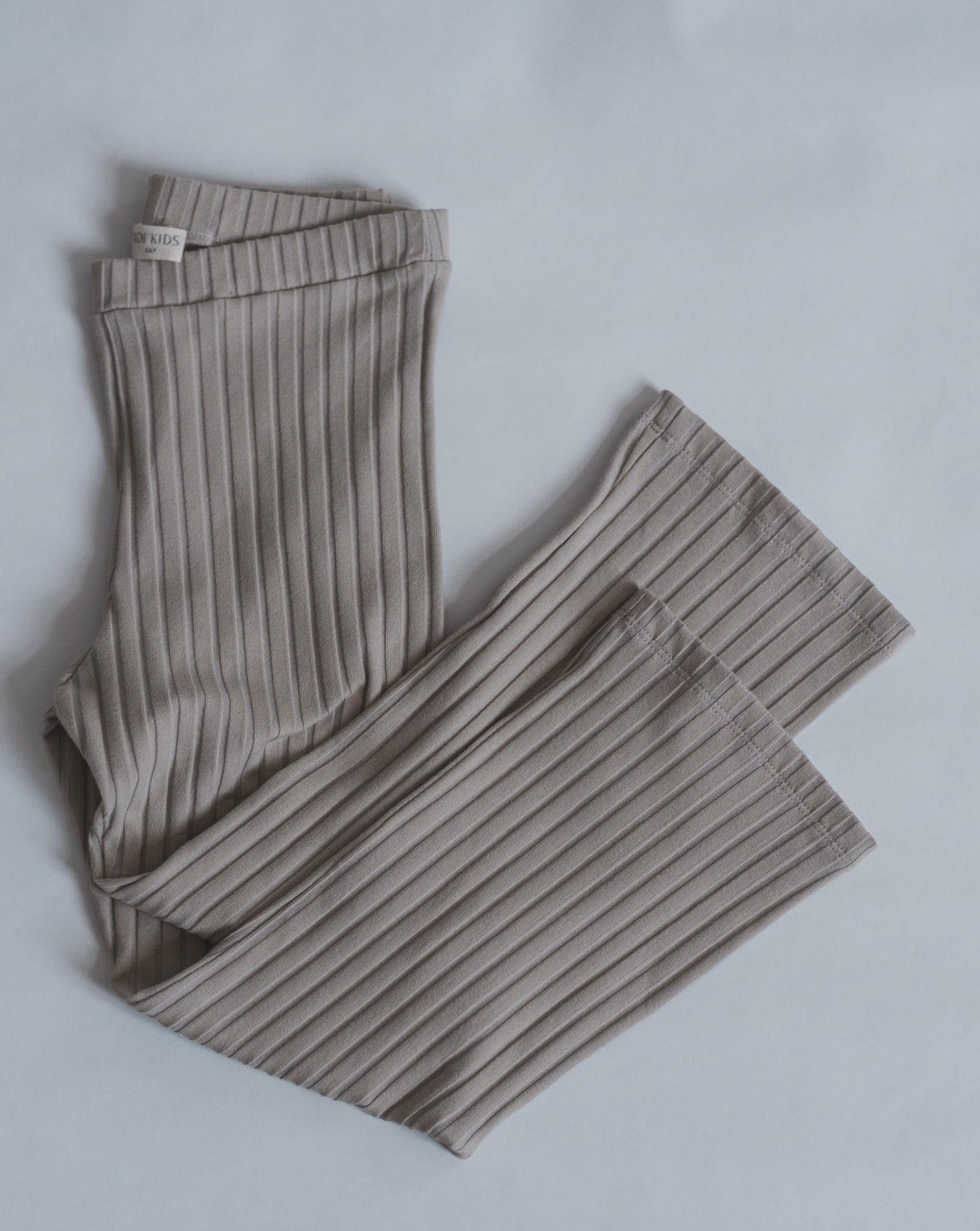 Beige ribbed leggings with a wide leg and adjustable waist.