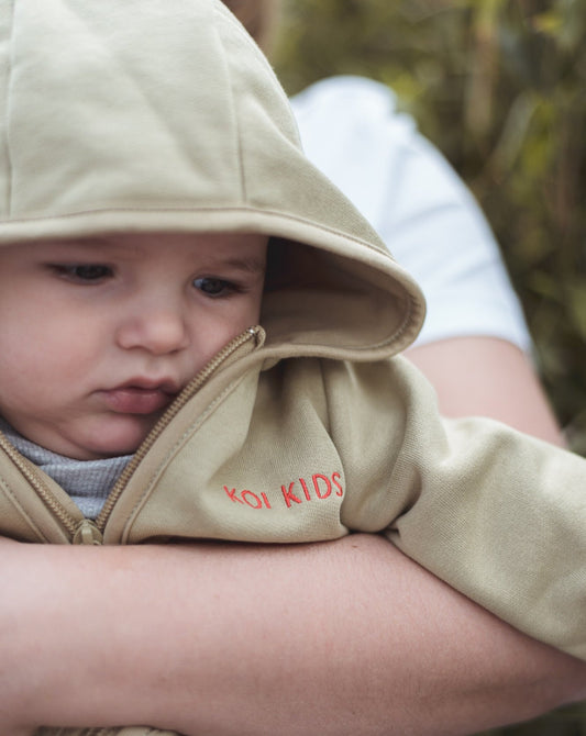 Beige overall with zipper and hoodie. Made of the softest brushed organic cotton jersey.