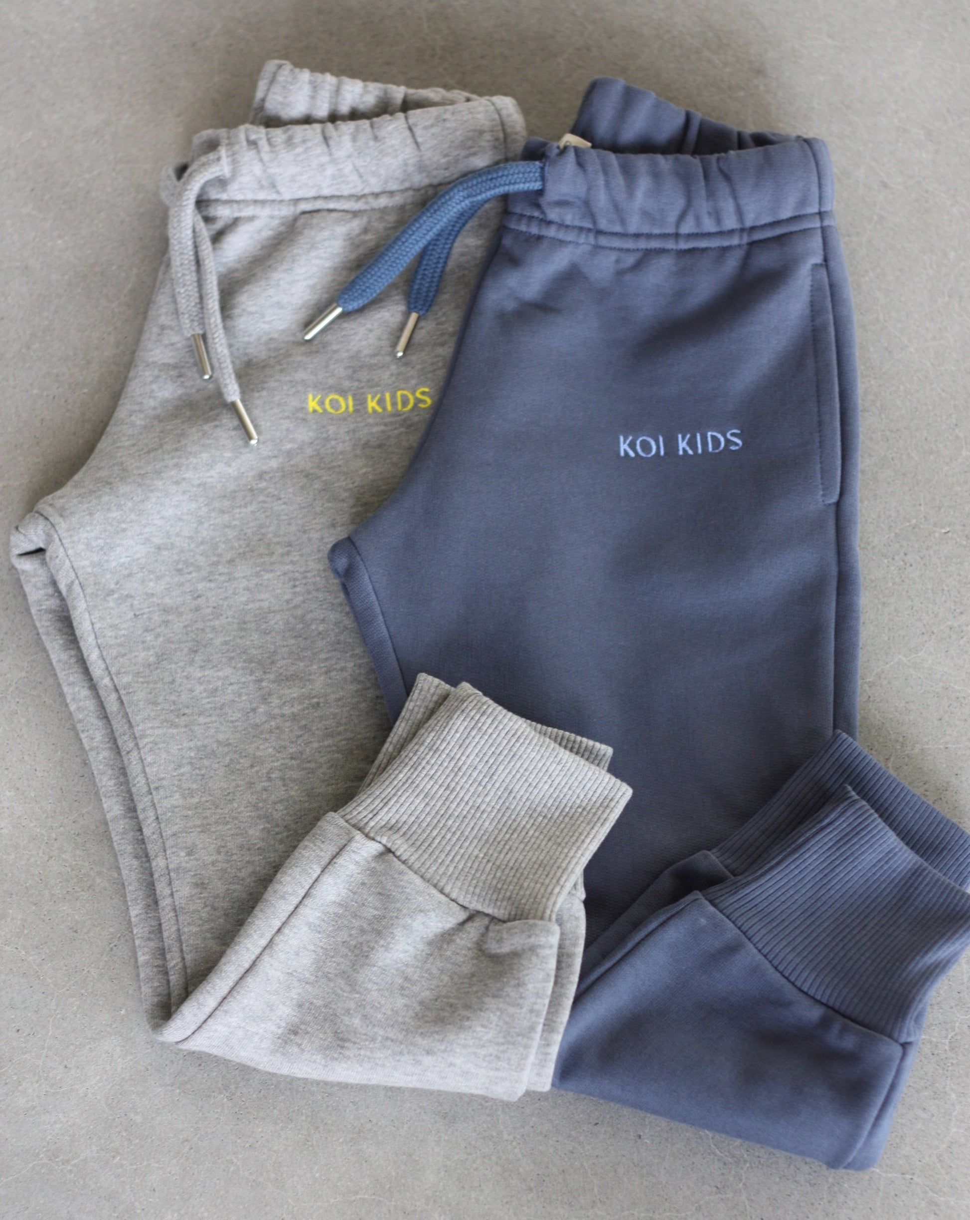 Grey mélange and denim blue sweatpants with a drawstring elasticated waist, logo embroidery, side pockets and ribbed cuffs.